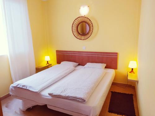1 dormitorio con 1 cama con espejo y 2 lámparas en Casa Atlantica, en Alcalá