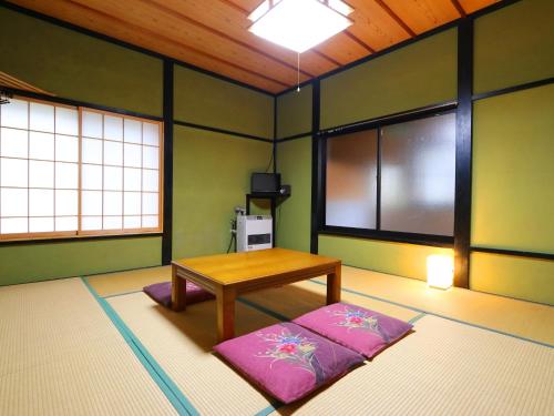 a room with a table and a bench in it at Warabiso in Yuzawa