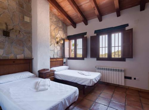 a room with two beds and a stone wall at Villa Vinyent - Plusholidays in Calpe