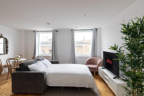 sala de estar con cama y sofá en homely – Central London Prestige Apartments Camden, en Londres