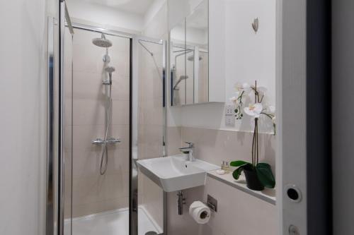 biała łazienka z umywalką i prysznicem w obiekcie homely – Central London Prestige Apartments Camden w Londynie