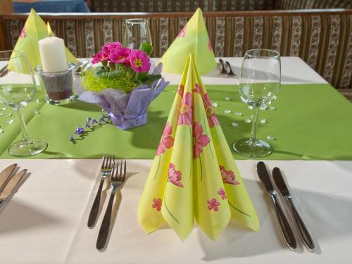 a table with a white table cloth with napkins on it at Berghotel Türlwand in Ramsau am Dachstein