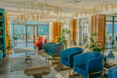 a waiting room with blue chairs and plants at Mtserlebi Resort in K'vishkhet'i