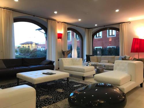 a living room with white furniture and a large window at Relais Santo Stefano in Sandigliano
