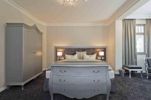 a bedroom with a large bed with a dresser and a dresser at Cityappartement am Belvedere in Weimar