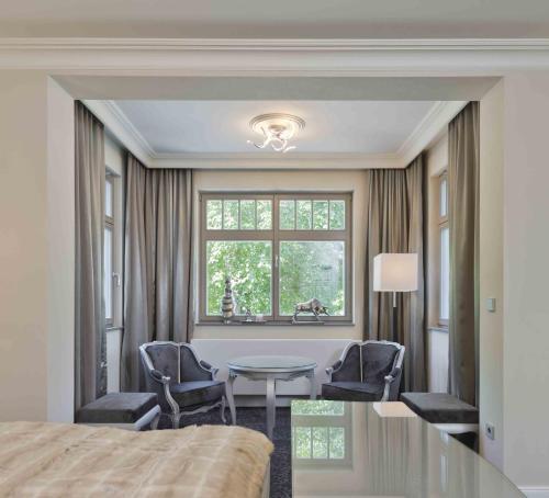 a bedroom with a table and chairs and a window at Cityappartement am Belvedere in Weimar