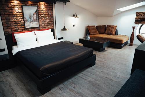 1 dormitorio con 1 cama grande y 1 sofá en Lomonosov Hotel, en San Petersburgo
