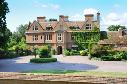an old house with a driveway in front of it at Horwood House Hotel in Milton Keynes