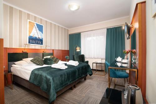 ブワディスワボボにあるHotel Rejsのベッドとデスクが備わるホテルルームです。