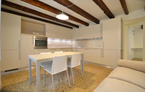 a kitchen with a table and white chairs at Dimora Frari, vicino Campo Santa Margherita in Venice