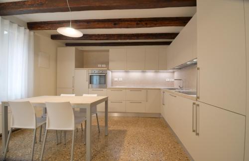 a kitchen with a table and chairs in a room at Dimora Frari, vicino Campo Santa Margherita in Venice