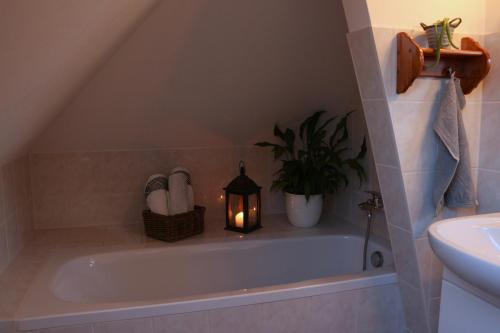 een badkamer met een bad met een kaars erin bij Ferienwohnung Spatzennest in Frankenberg