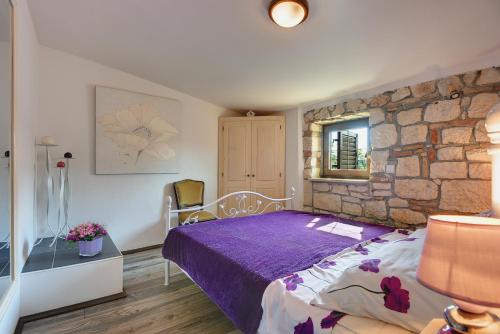 - une chambre avec un lit et un mur en pierre dans l'établissement Holiday Home Agneza, à Medulin