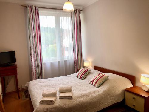 a bedroom with a bed with two towels on it at Sosnowe Zacisze in Białystok