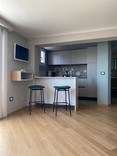 a kitchen with two stools in front of a counter at SUITE 168 in Pescara