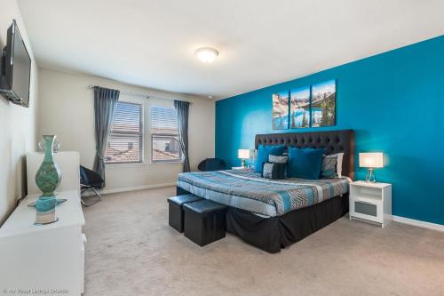 Resort Townhome wPRIVATE Pool & BBQ, near Disney في كيسيمي: غرفة نوم بجدران زرقاء وسرير في غرفة
