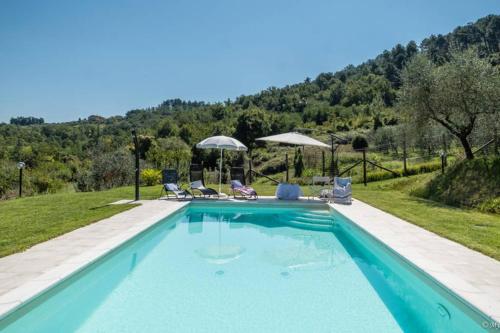 una piscina con sillas y sombrillas en una colina en Alla Bella Aurora with Amazing POOL in Tuscany, en Lucca
