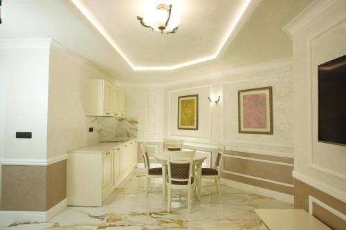 Art Complex Anel في سوزوبول: مطبخ أبيض مع طاولة وكراسي