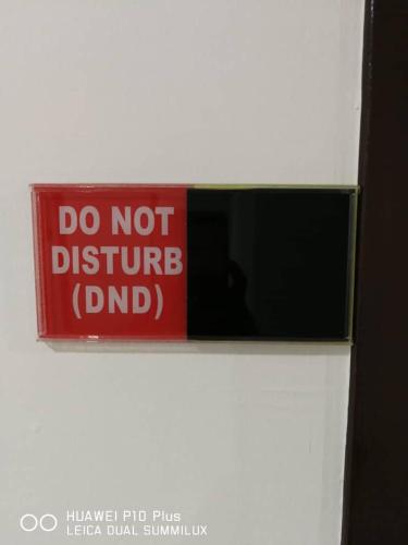 a red sign that says do not disturb dnd at Grand Bagan Hotel in Butterworth