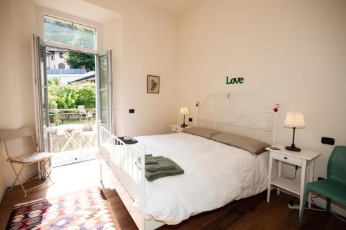 a bedroom with a white bed and a green chair at Casa Julia in Menaggio