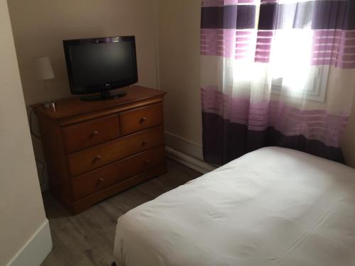 a bedroom with a bed and a television on a dresser at Hostellerie de Pavillon Saint-Hubert in Gouvieux