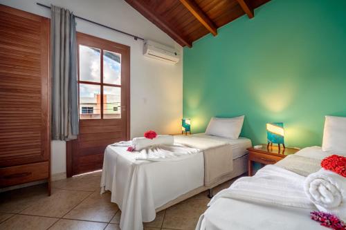 sypialnia z 2 łóżkami i oknem w obiekcie Capoeira Village w mieście Porto Seguro