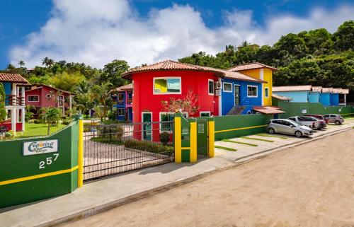 a row of houses with cars parked in front of them at Capoeira Village in Porto Seguro