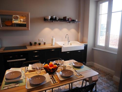 eine Küche mit einem Tisch mit Stühlen und einem Waschbecken in der Unterkunft Cosy Home Colmar - Petite Venise in Colmar