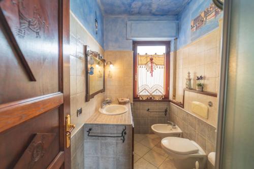 a bathroom with a sink and a toilet and a window at Alghero Amantiosu Casa Vacanze in Alghero