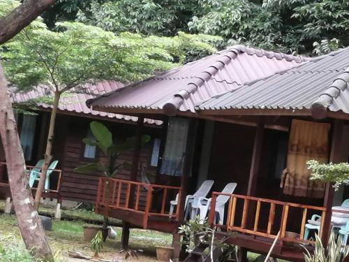 a cabin in the woods with chairs in front of it at Eco Bungalow in Ko Phayam