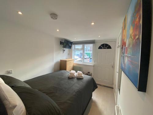 a bedroom with a bed with two shoes on it at Comfortable cosy double ensuite room 'Karibu' in Cherry Hinton