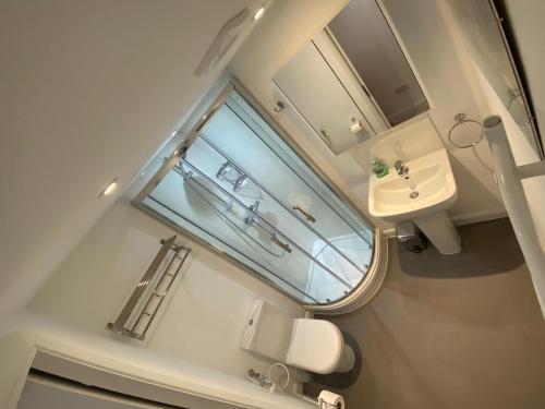 a small bathroom with a sink and a window at Comfortable cosy double ensuite room 'Karibu' in Cherry Hinton