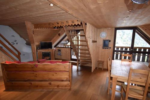 eine Blockhütte mit einem Esszimmer und einer Treppe in der Unterkunft VAUJANYLOCATIONS - Chalet Perin in Vaujany