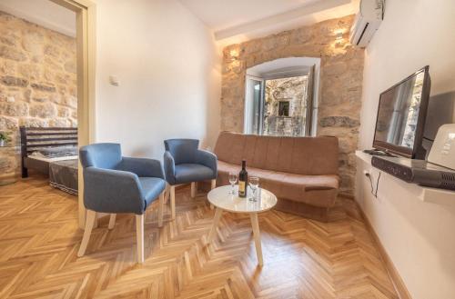 a living room with a couch and chairs and a table at Apartment Forteca Lux in Perast