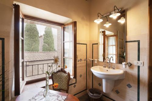 baño con lavabo y ventana en Villa Montecastello en Monteriggioni