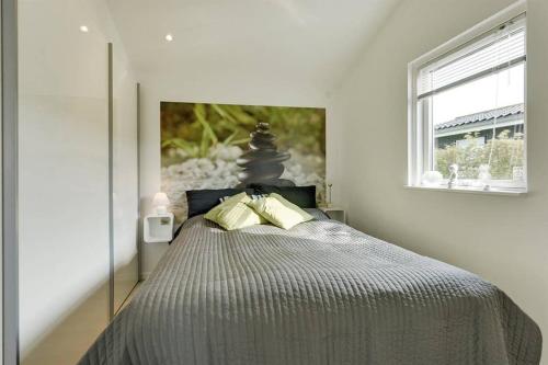 1 dormitorio con 1 cama con una pintura en la pared en Eksklusiv sommerhus beliggende i vandkanten, en Munkebo