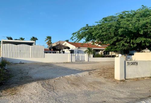 a white fence in front of a house at Tu Casita en Aruba in Palm-Eagle Beach