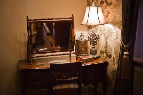 a desk with a mirror and a lamp on it at The Plough Inn in York
