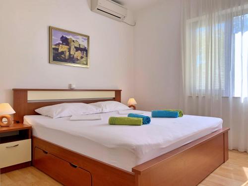 a bedroom with a large bed with two pillows on it at Apartments Viola in Šilo