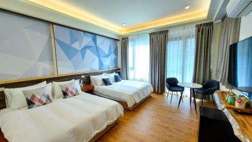 pokój hotelowy z 2 łóżkami i telewizorem w obiekcie 魚兒尖尖民宿 w mieście Yuchi