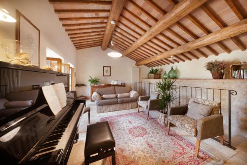 a living room with a piano and a couch at Villa Montecastello in Monteriggioni