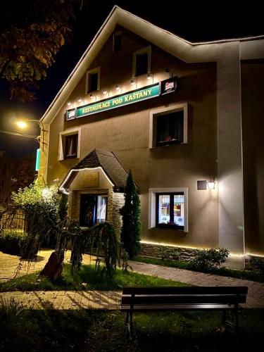 a hotel building with a bench in front of it at Hotel & Restaurant Pod Kaštany in Krupka - Marsov