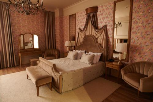 a bedroom with a bed and a chair and a mirror at Hotel Royal in Belgorod