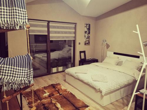 een slaapkamer met een bed en een groot glazen raam bij Арт Мезонет Salem in Velingrad