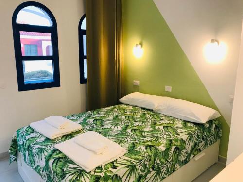 ein Bett mit zwei Handtüchern auf einem Zimmer in der Unterkunft PLAYMAR TROPICAL in Maspalomas