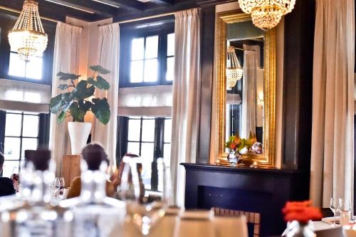 a dining room with a table and a mirror at Boutique Hotel 't Lansink in Hengelo