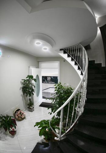 a spiral staircase in a building with potted plants at Hotel Trionfal in Qualiano