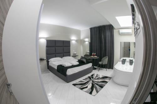 a bedroom with a large bed and a bathroom at Hotel Trionfal in Qualiano