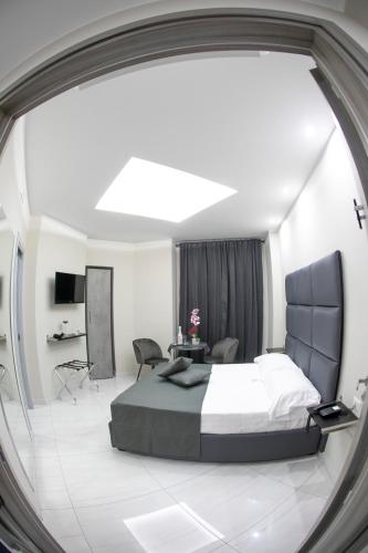 a bedroom with a large bed and a table and chairs at Hotel Trionfal in Qualiano