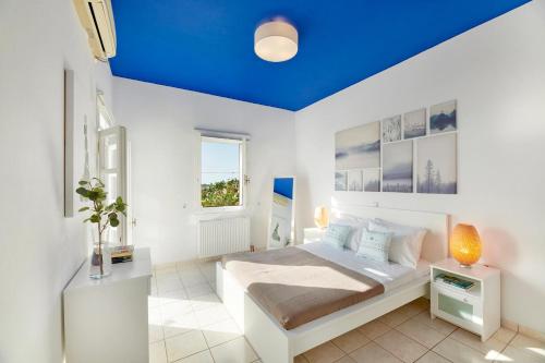 キモロスにあるAria Kimolos Residenceの青い天井のベッドルーム1室